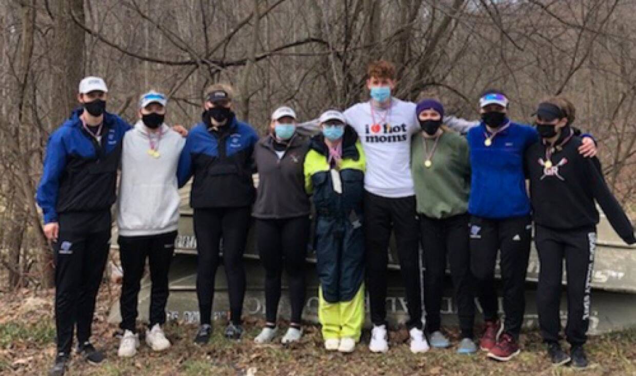 Rowing athletes pose before taking to the water with teammates.